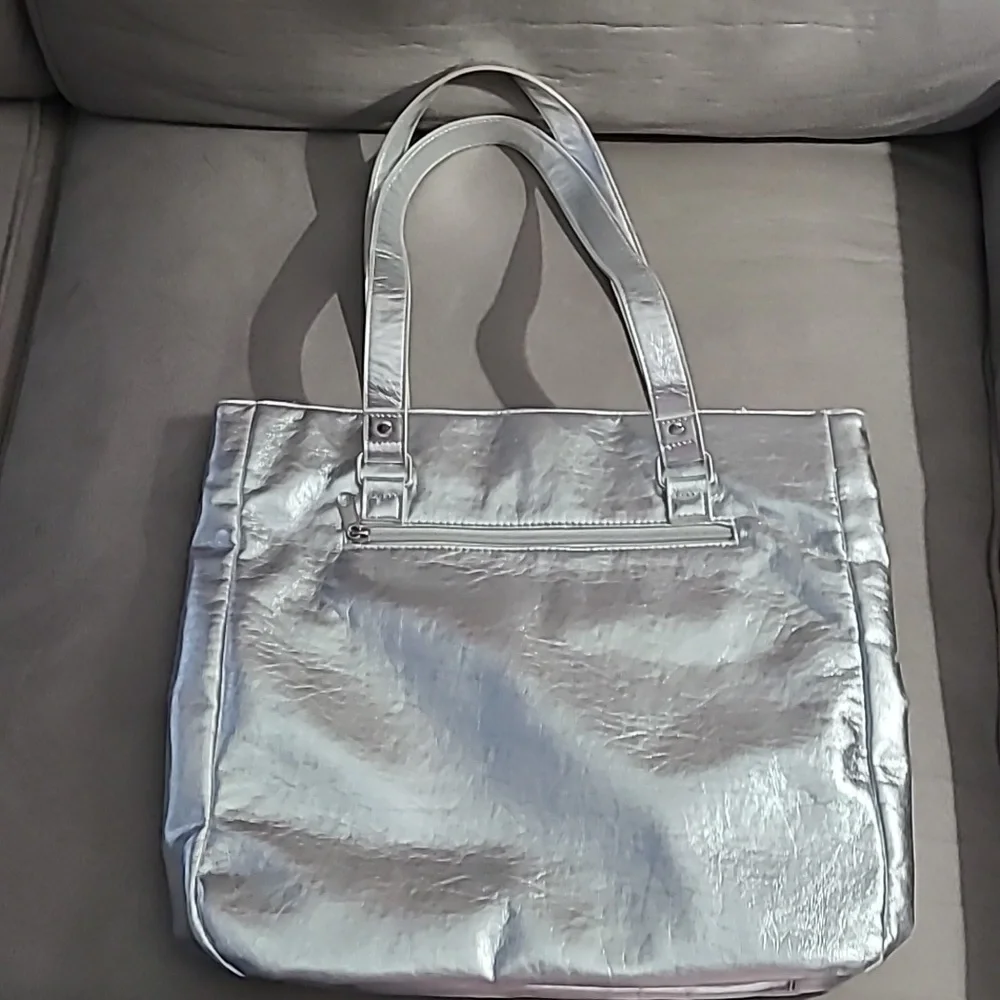 Shiny silver metallic handbag. Outside pockets snap closure‎ clean inside